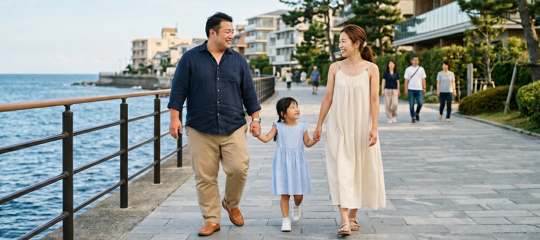海沿いの遊歩道を歩く家族